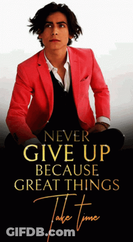 Man In Red Jacket In Front Of Never Give Up Sign GIF
