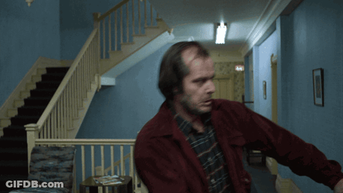Man In Red Jacket In Hallway Near Stairs GIF