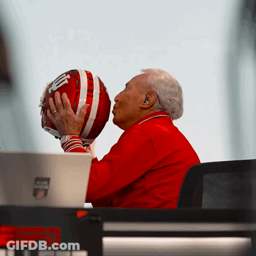 Man In Red Jacket Kissing Football Helmet GIF