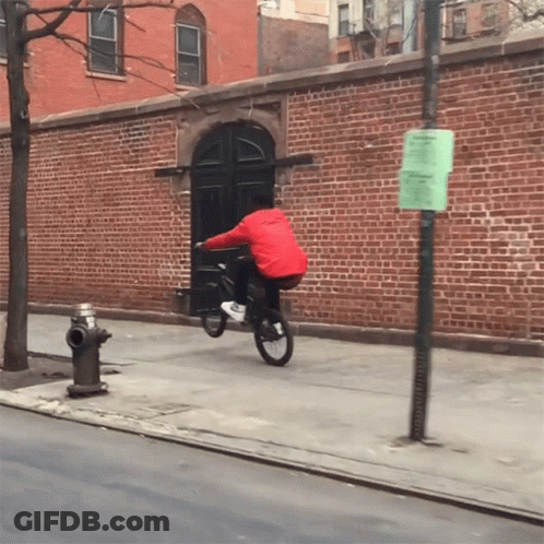 Man In Red Jacket Riding Bike Beside Fire Hydrant GIF