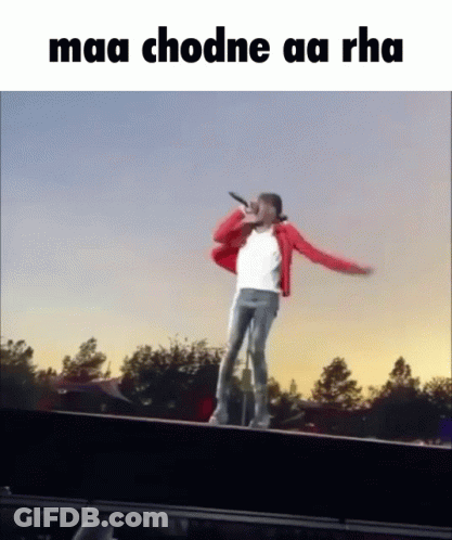 Man In Red Jacket Singing Into Microphone On Railing GIF