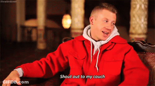 Man In Red Jacket Sitting On Couch Talking GIF