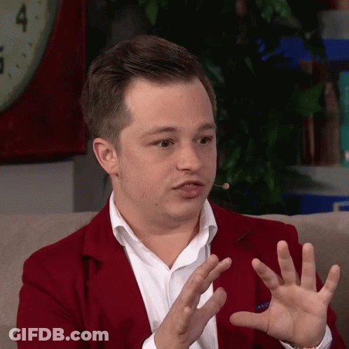 Man In Red Jacket Sitting On Couch With Hands Outstretched GIF
