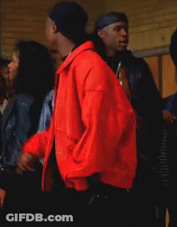 Man In Red Jacket Smoking Cigarette In Crowd GIF