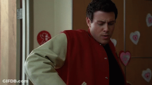 Man In Red Jacket Standing Before Heart Wall GIF