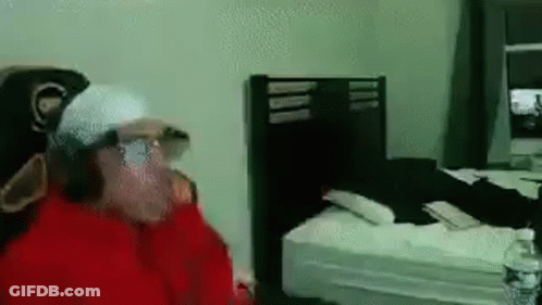 Man In Red Jacket Standing In Bedroom GIF
