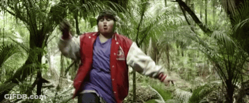 Man In Red Jacket Standing In Jungle GIF