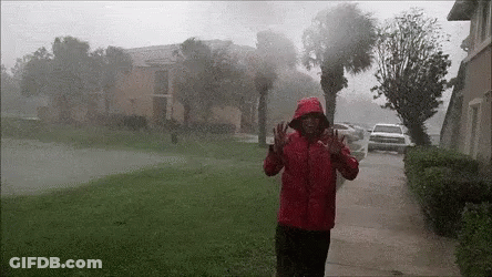 Man In Red Jacket Standing In Rain Before Hurricane GIF