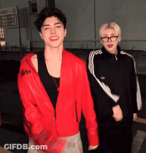 Man In Red Jacket Standing Next To Another Man GIF