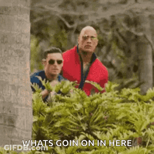 Man In Red Jacket Standing Next To Man In Blue Shirt GIF
