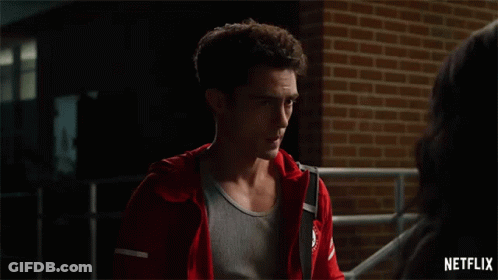 Man In Red Jacket Standing Next To Woman In Front Of Brick Wall GIF