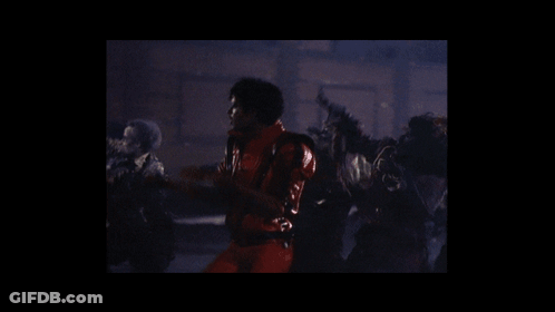 Man In Red Jacket Surrounded By Zombies GIF