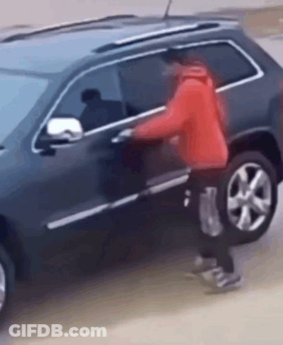 Man In Red Jacket Trying To Get Into Black SUV GIF