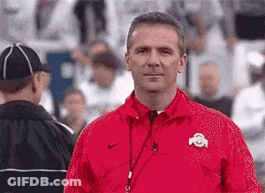 Man In Red Jacket With Letter O Standing On Field GIF
