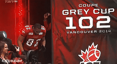 Man In Red Jersey 82 In Front Of Grey Cup 102 Banner GIF