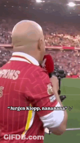 Man In Red Jersey Holding Microphone Talking To Crowd GIF