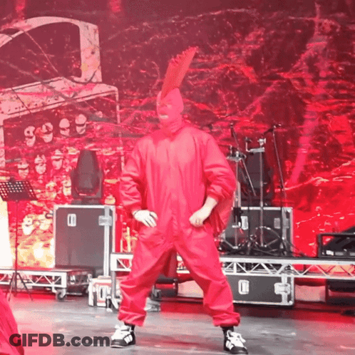 Man In Red Jumpsuit Dancing With Drum Set GIF