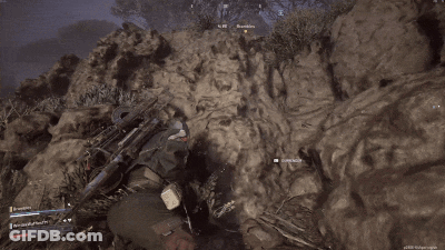 Man In Red Jumpsuit Holding Rifle GIF