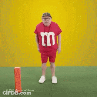 Man In Red M&Ms Shirt Dancing On Field GIF