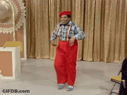 Man In Red Pants Dancing On Stage In Front Of Gold Curtain GIF