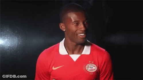 Man In Red PSV Jersey Smiling In Dark GIF
