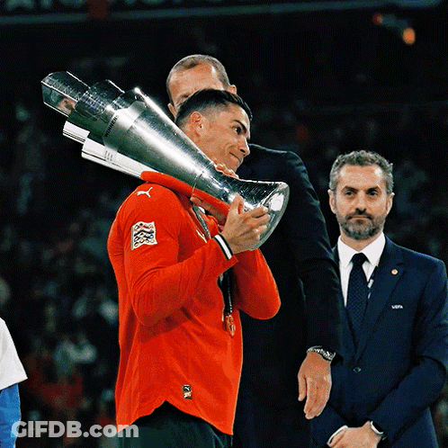 Man In Red Puma Shirt Holding Large Trophy GIF