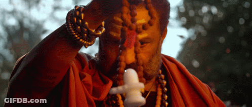 Man In Red Robe Holding Small Statue GIF