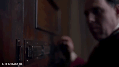 Man In Red Robe Opening Door With Latch GIF