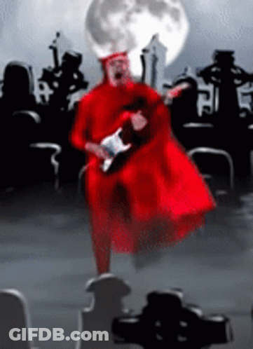 Man In Red Robe Playing Guitar In Cemetery With Full Moon GIF