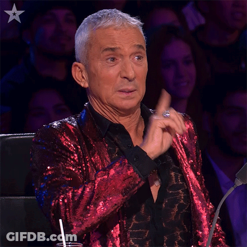 Man In Red Sequined Jacket Sitting Before Crowd GIF
