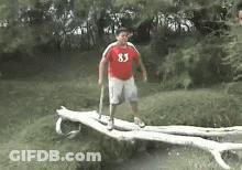 Man In Red Shirt 83 Standing On Log GIF
