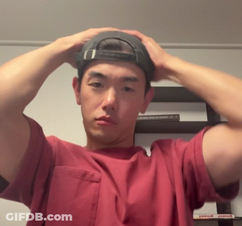 Man In Red Shirt Adjusting Black Hat GIF