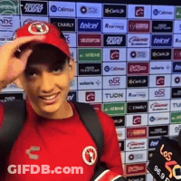 Man In Red Shirt And Hat In Front Of Telcel Ads GIF