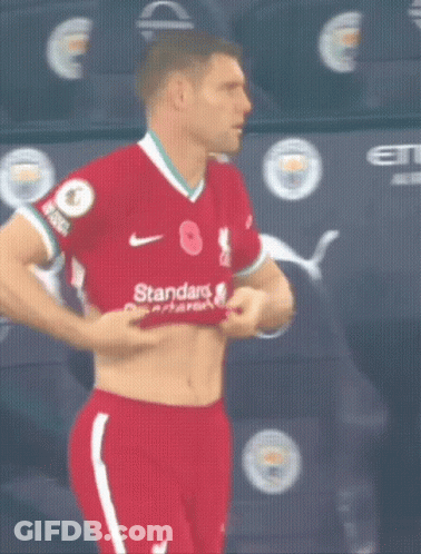 Man In Red Shirt And Shorts Removing Shirt GIF