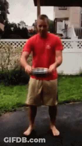 Man In Red Shirt And Tan Shorts Holding Plate GIF