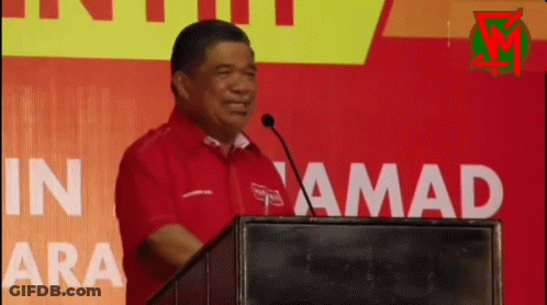 Man In Red Shirt At Podium With Microphone GIF