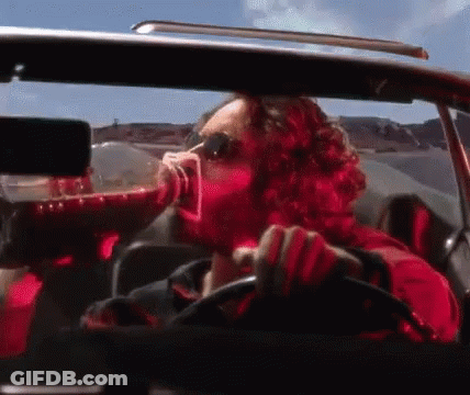 Man In Red Shirt Drinking While Driving GIF
