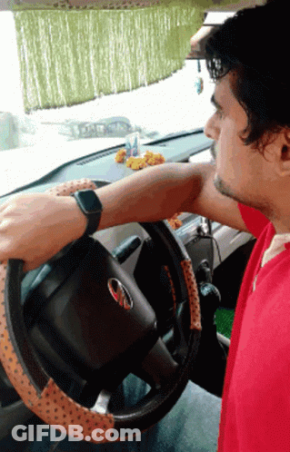 Man In Red Shirt Driving Car With Mahindra Logo GIF