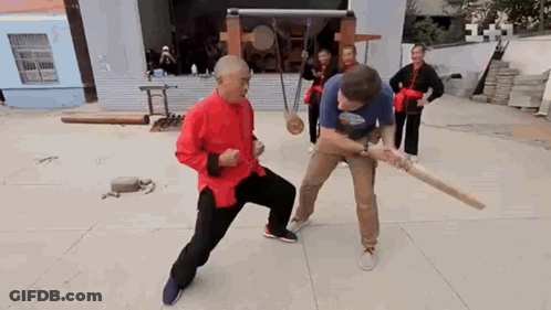 Man In Red Shirt Fighting With Wooden Bat GIF
