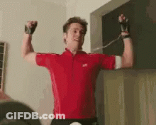 Man In Red Shirt Flexing Muscles Holding Rope GIF