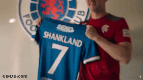 Man In Red Shirt Holding Blue Shankland Shirt GIF