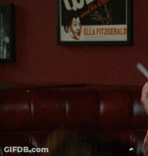 Man In Red Shirt Holding Knife In Mouth GIF