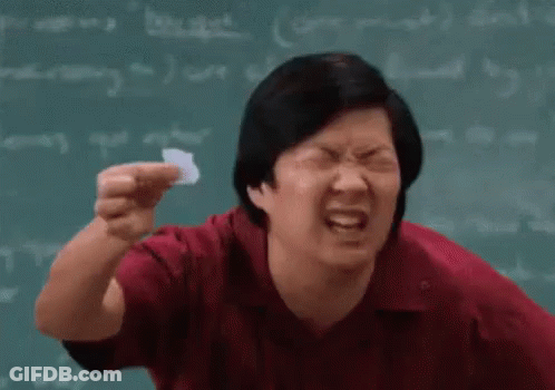 Man In Red Shirt Holding Paper In Front Of Chalkboard GIF