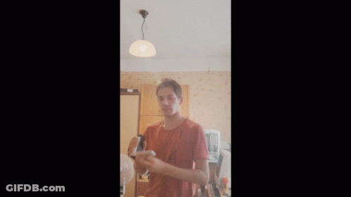 Man In Red Shirt Holding Something GIF