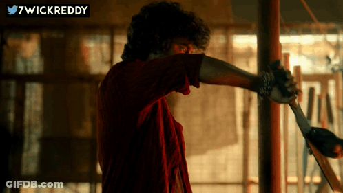 Man In Red Shirt Holding Sword In Front Of Twitter Logo GIF