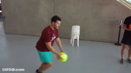 Man In Red Shirt Holding Tennis Ball With Man In Blue Shorts GIF