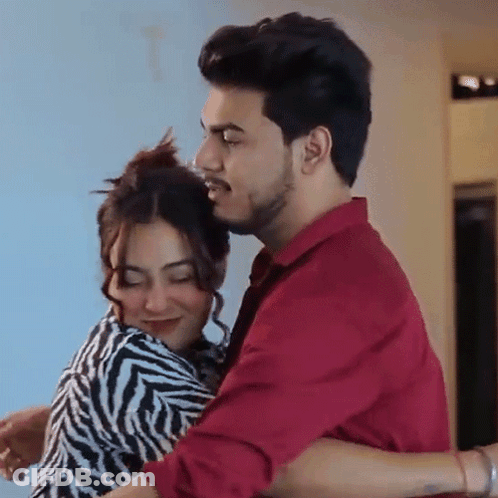 Man In Red Shirt Holding Woman In Zebra Print Dress GIF