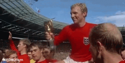 Man In Red Shirt Holds Trophy In Front Of Crowd GIF