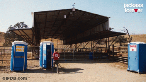 Man In Red Shirt In Front Of Blue Portable Toilets Saying Zone 4 And Pod 2 GIF