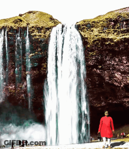 Man In Red Shirt In Front Of Waterfall GIF